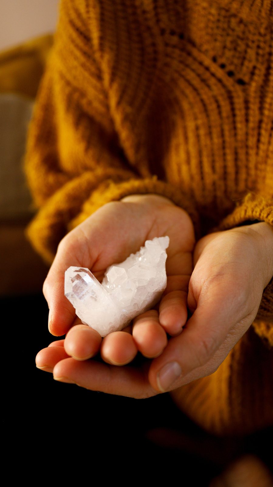 Clear quartz cradled in open hands.