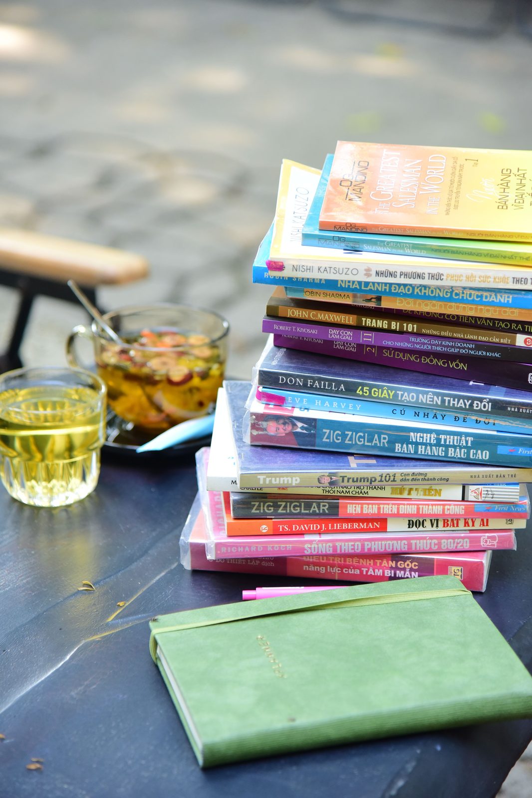 A stack of well-read books, a notebook and tea on a quiet table.