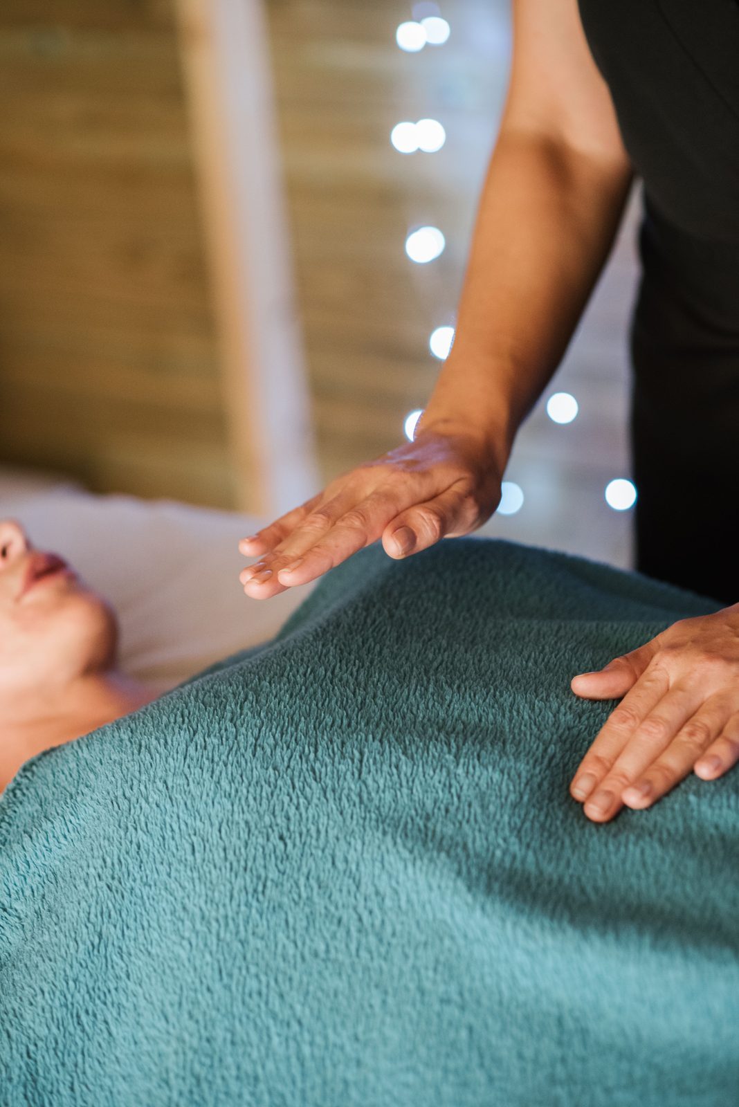 Hands held just above the body in a reiki session.