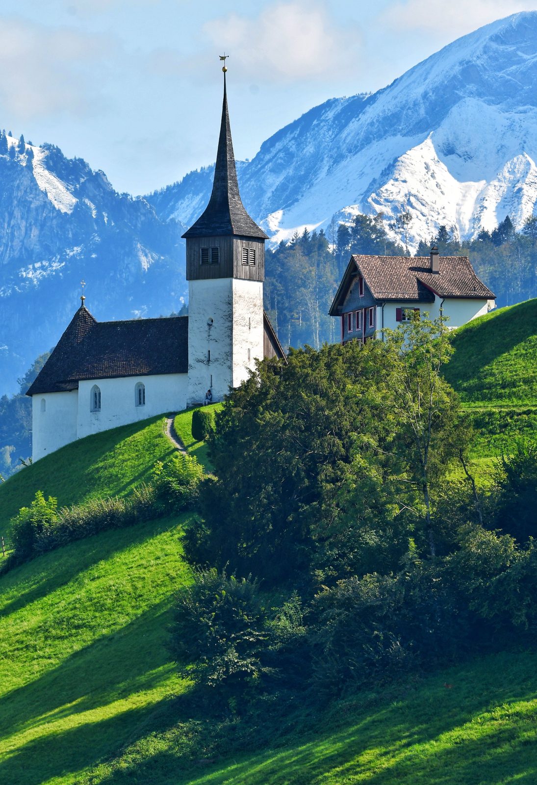 A hillside church beneath the Swiss Alps.